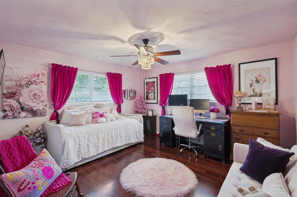 The second bedroom is at the rear of the house and offers laminate wood flooring, a chandelier fan, and an en-suite powder bathroom.