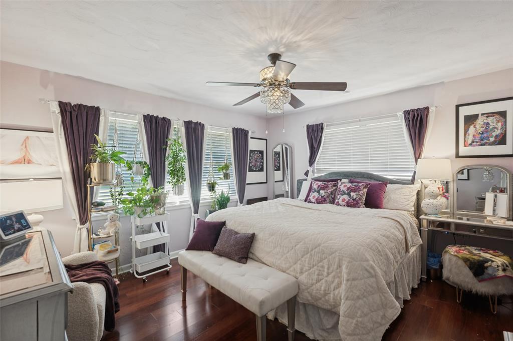 Either of the bedrooms could serve as the primary. This one is at the front of the house and has great natural light, laminate wood flooring, and a chandelier fan.