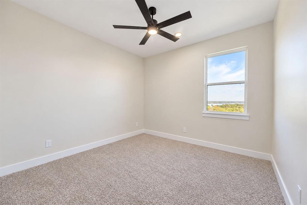 Neutral wall tones, wall-to-wall carpeting, single-hung window, and a matte black ceiling fan with integrated lighting