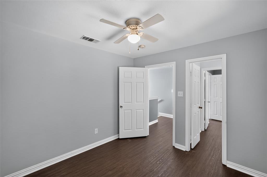 Neutral wall paint, wood-finish flooring, and a ceiling fan with integrated lighting
