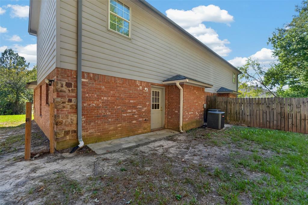 Exterior featuring a combination of brick and horizontal siding, a private backyard, and a wooden privacy fence