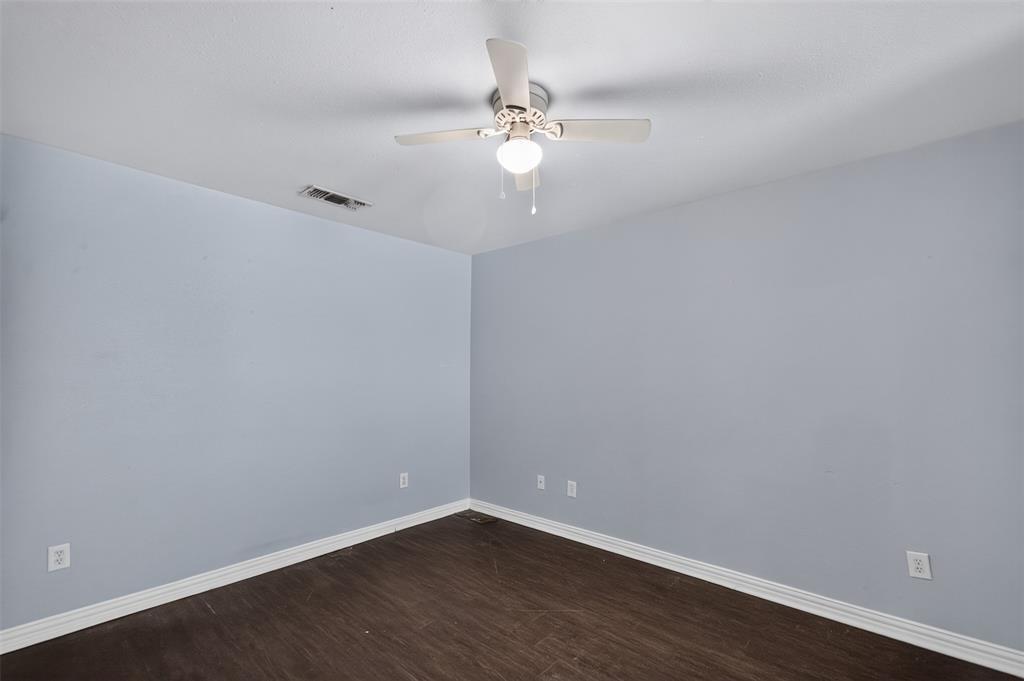 Room featuring wood-finish flooring, light-toned walls, and a ceiling-mounted light fixture with a fan