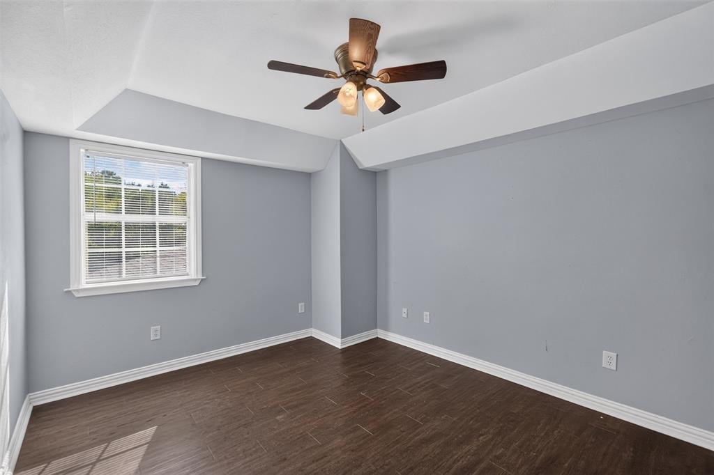 Tray ceiling, wood-finish flooring, and a multi-light ceiling fan