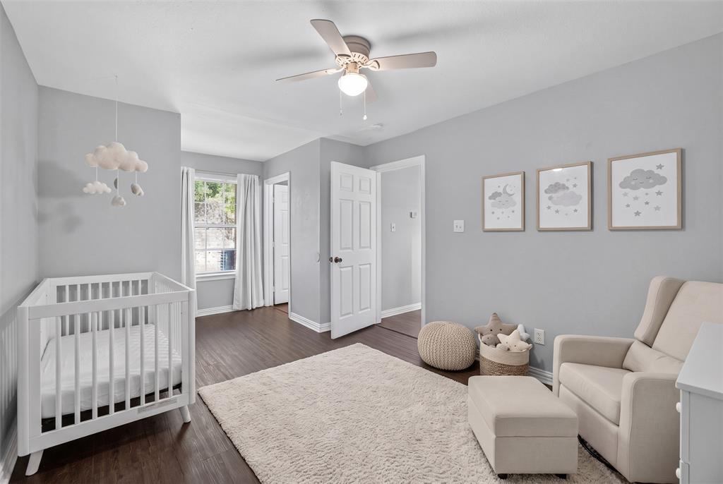 Interior room featuring wood-finish flooring, a ceiling fan with integrated lighting, and a multi-pane window