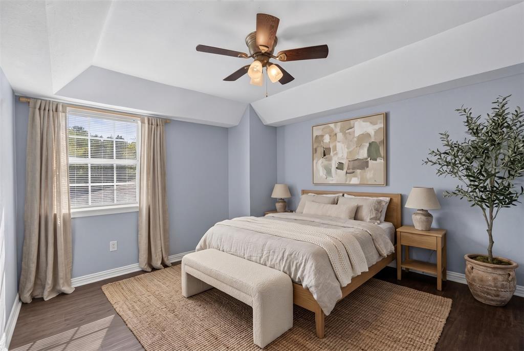 Tray ceiling, wood-finish flooring, and a multi-light ceiling fan