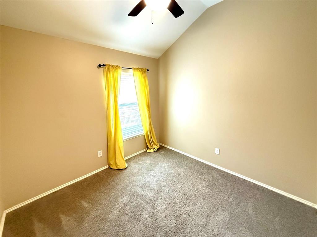Vaulted ceilings, carpeted flooring, and a single-light window featuring a fixed curtain rod