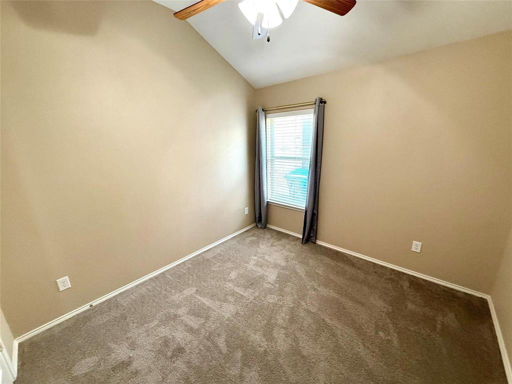 Vaulted ceiling featuring a central multi-blade ceiling fan and wall-to-wall carpeting Vaulted ceiling featuring a central multi-blade ceiling fan and wall-to-wall carpeting