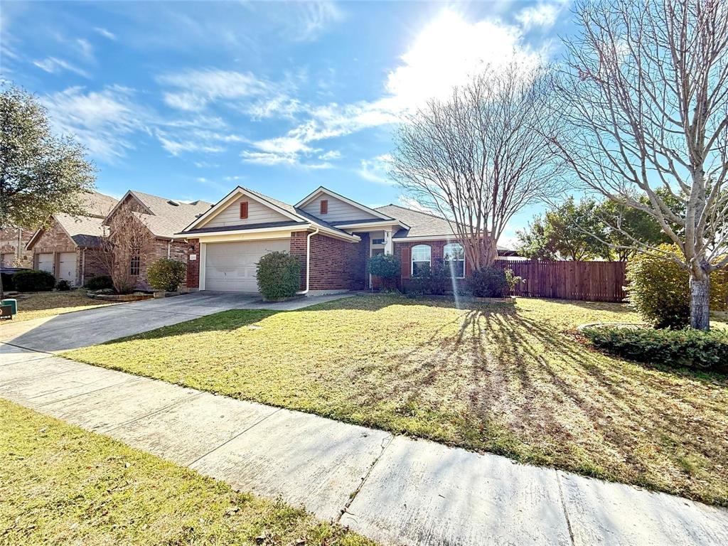 Single-story residence featuring a brick and siding exterior, front-facing two-car garage, and a manicured lawn