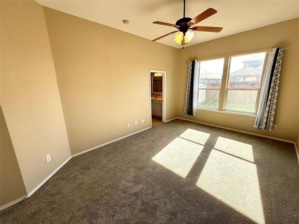 High-ceilinged room featuring neutral carpeting, a central ceiling fan with multi-light fixture, and dual windows High-ceilinged room featuring neutral carpeting, a central ceiling fan with multi-light fixture, and dual windows