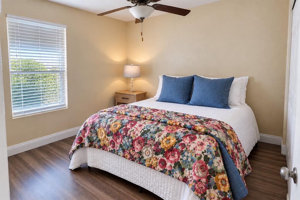 Wood-finish flooring, ceiling fan with integrated lighting, and horizontal window blinds