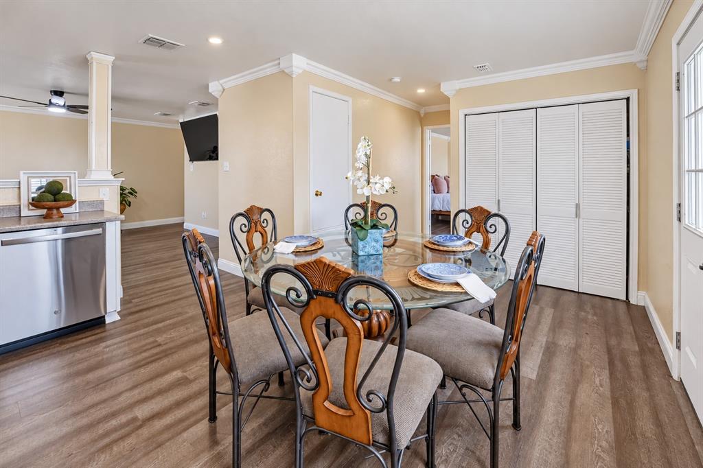 Wood-finish flooring, crown molding, stainless steel dishwasher, and louvered closet doors