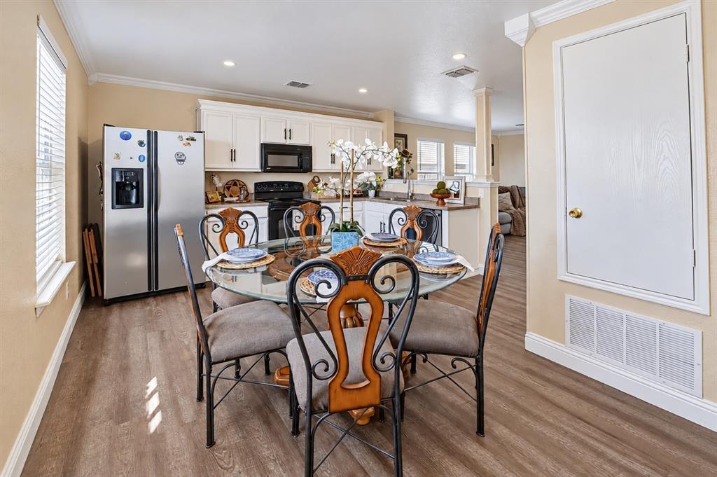Kitchen area featuring white cabinetry, wood-finish flooring, recessed lighting, and a stainless steel refrigerator