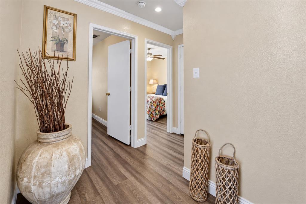 Interior hallway featuring wood-finish flooring, crown molding, and recessed lighting