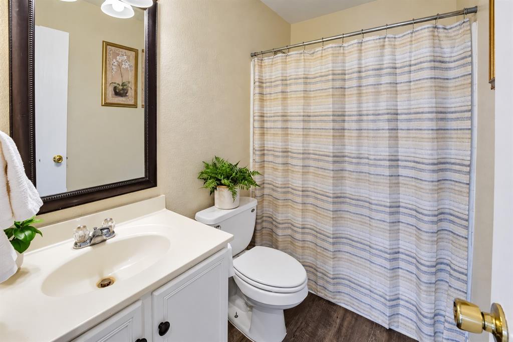 Bathroom featuring a vanity with integrated sink, wood-finish flooring, and a framed mirror