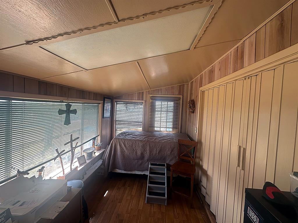 Wood-finish paneling, wood-finish flooring, recessed lighting, and expansive windows featuring horizontal blinds