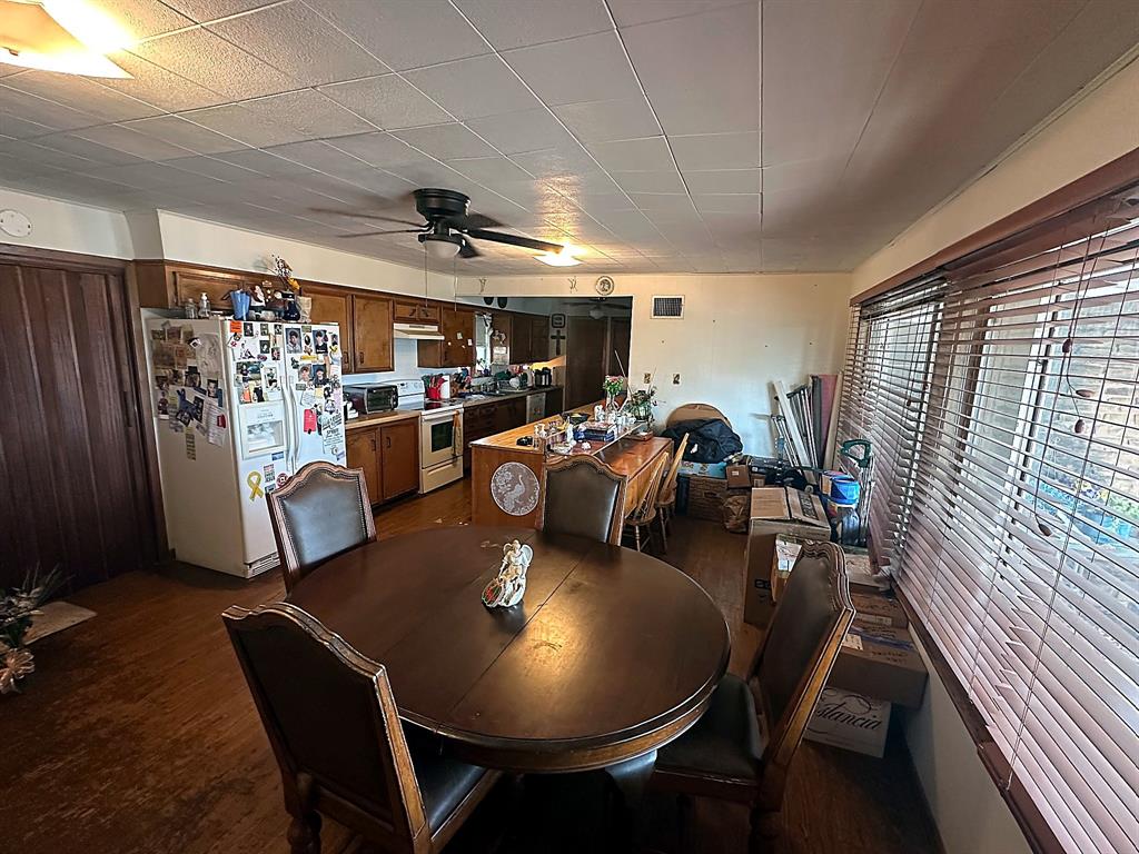 Kitchen featuring wood cabinetry, a breakfast bar, wood-finish flooring, and horizontal window blinds