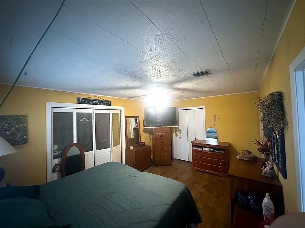 Interior space featuring wood-finish flooring, white paneled closet doors, and a ceiling-mounted light fixture