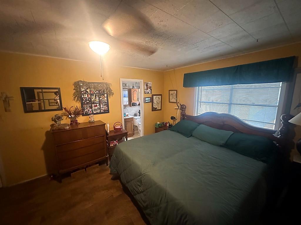 Wood-finish flooring, ceiling-mounted light fixture, and window with horizontal blinds