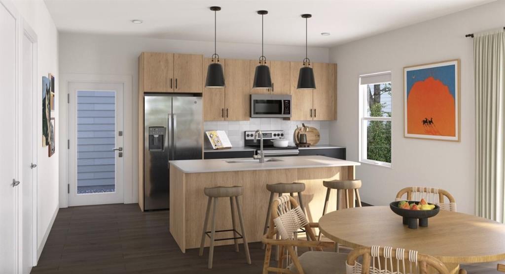 Kitchen featuring tasteful backsplash, stainless steel appliances, a kitchen island with sink, light brown cabinets, and decorative light fixtures Kitchen featuring tasteful backsplash, stainless steel appliances, a kitchen island with sink, light brown cabinets, and decorative light fixtures