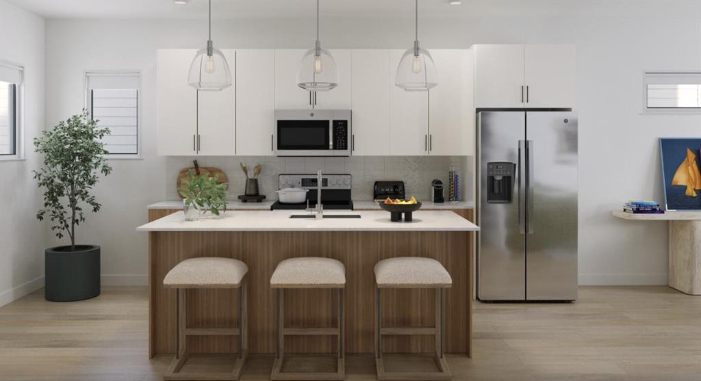 Kitchen with stainless steel appliances, light wood-type flooring, pendant lighting, decorative backsplash, and a kitchen island with sink Kitchen with stainless steel appliances, light wood-type flooring, pendant lighting, decorative backsplash, and a kitchen island with sink