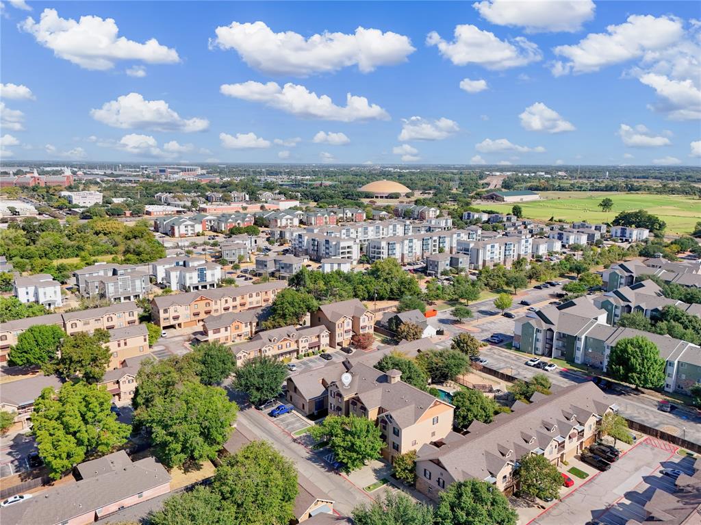 Aerial perspective of a multi-building residential community featuring pitched shingled roofs, mature tree canopy, and paved surface parking Aerial perspective of a multi-building residential community featuring pitched shingled roofs, mature tree canopy, and paved surface parking