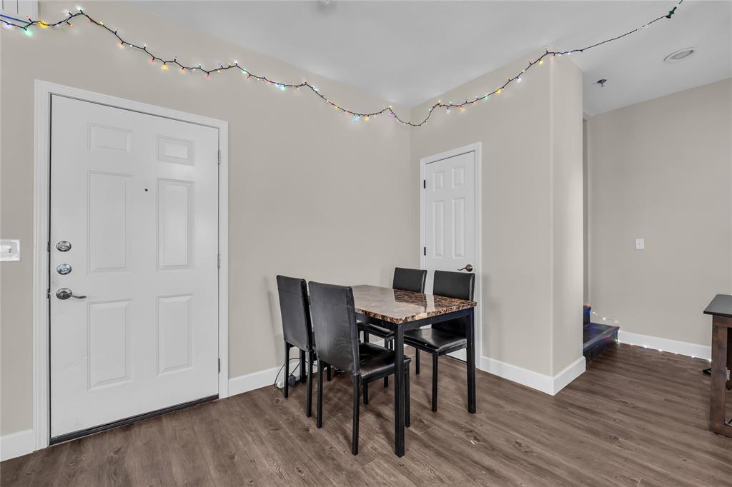 Interior space featuring wood-finish flooring, a multi-panel entry door with polished metal hardware, and a single-panel interior door