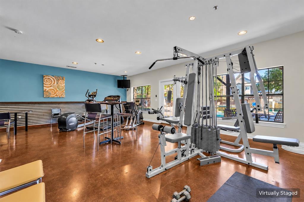 Fitness room featuring polished concrete flooring, recessed lighting, and corrugated metal wall paneling