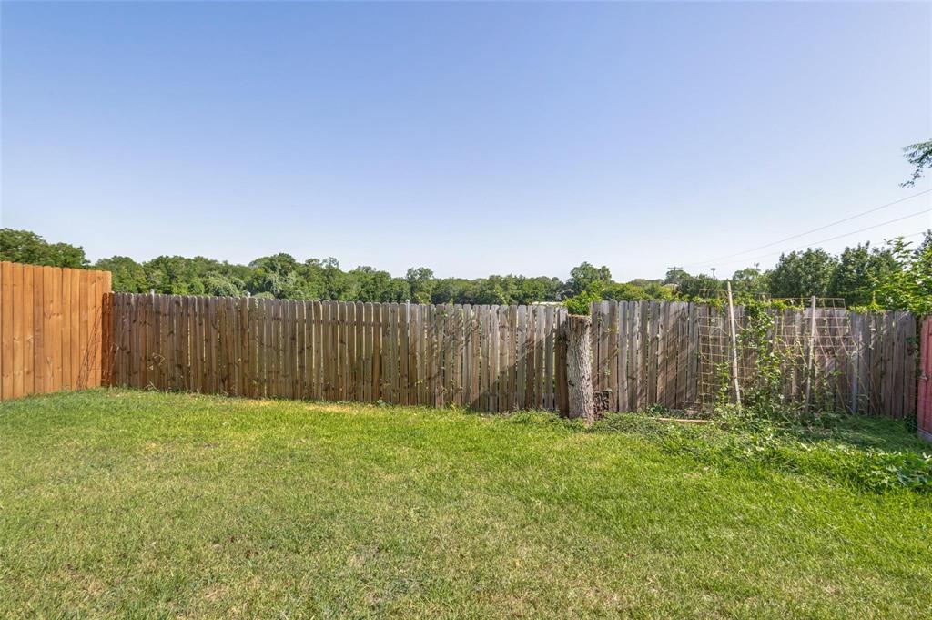 Fenced backyard featuring a grass lawn and wood picket privacy fencing
