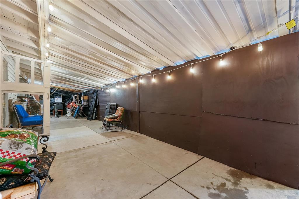 Covered patio featuring a concrete floor, a sloped metal roof, and solid panel wall partitions