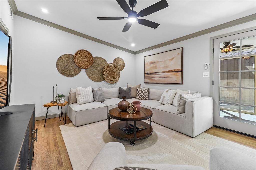 Hardwood flooring complemented by recessed lighting, crown molding, and a ceiling fan