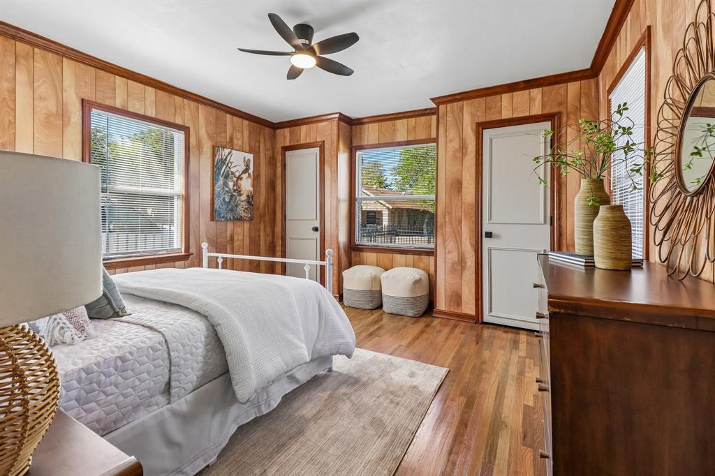 Wood-panel walls, wood-finish flooring, ceiling fan, and multiple windows