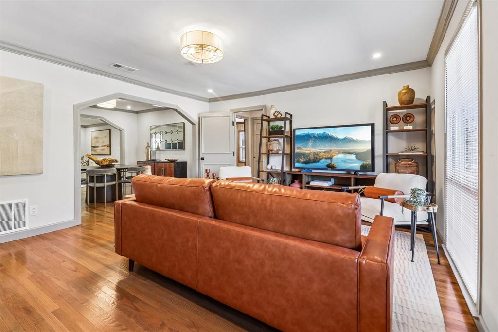 Hardwood flooring throughout, arched doorway, recessed lighting, crown molding, and a drum ceiling light fixture Hardwood flooring throughout, arched doorway, recessed lighting, crown molding, and a drum ceiling light fixture