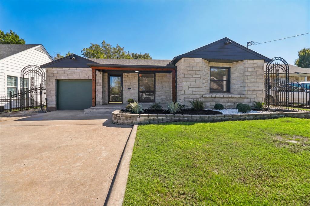 Stone facade with dark trim accents, covered entry, and a single-car garage Stone facade with dark trim accents, covered entry, and a single-car garage
