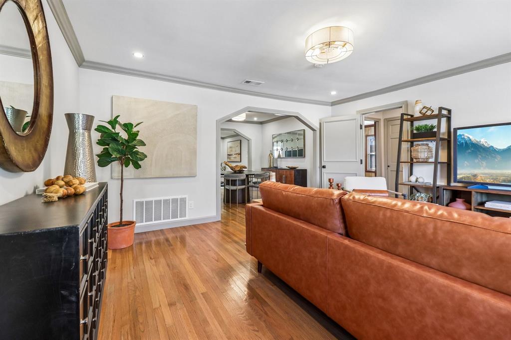 Hardwood flooring, recessed lighting, archway entry, crown molding, and a drum ceiling light fixture Hardwood flooring, recessed lighting, archway entry, crown molding, and a drum ceiling light fixture