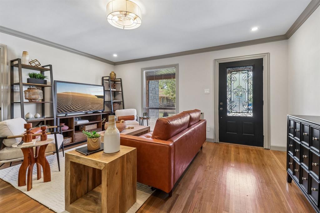 Hardwood flooring, recessed lighting, crown molding, a decorative entry door, and a flush mount ceiling fixture Hardwood flooring, recessed lighting, crown molding, a decorative entry door, and a flush mount ceiling fixture