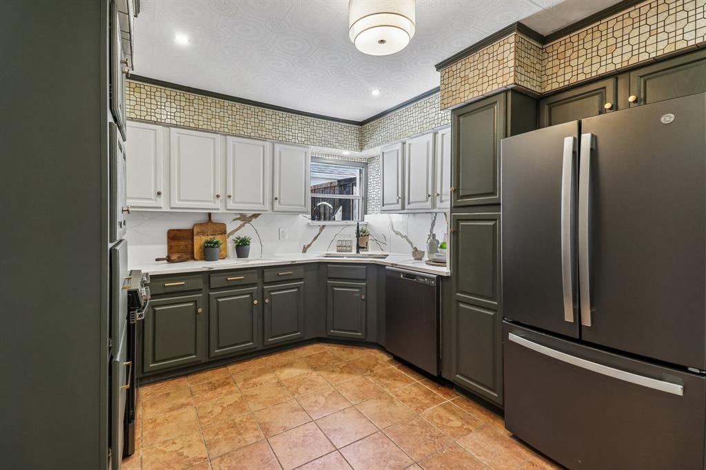 Matte finish appliances, two-tone cabinetry with gold-tone hardware, tile flooring, corner sink, and recessed lighting