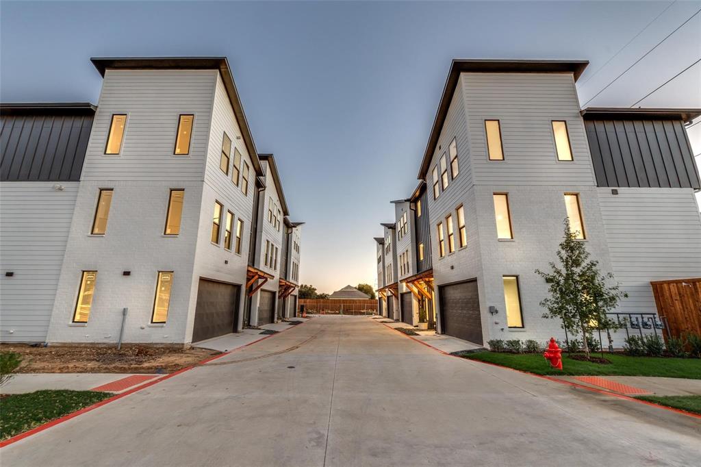 Contemporary multi-level exterior featuring horizontal lap siding, metal accents, attached garages, and large rectangular windows
