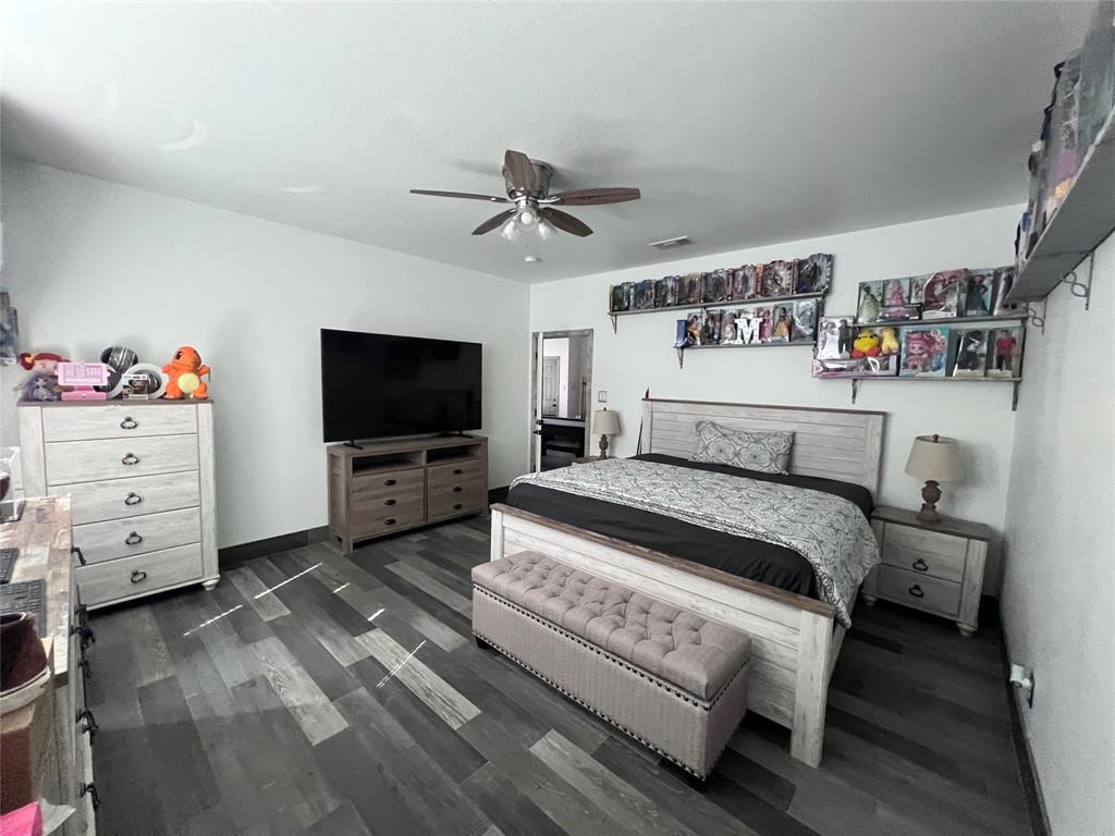 Wood-finish plank flooring throughout featuring a multi-tonal gray palette and a ceiling-mounted fan with integrated light fixture