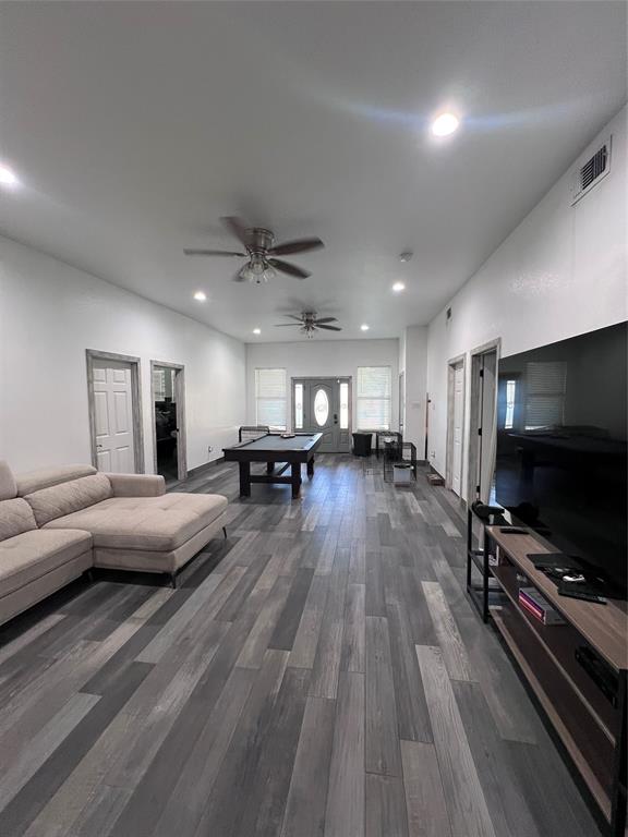 Wood-finish plank flooring, recessed lighting, dual ceiling fans, and an exterior door featuring decorative glass inlay