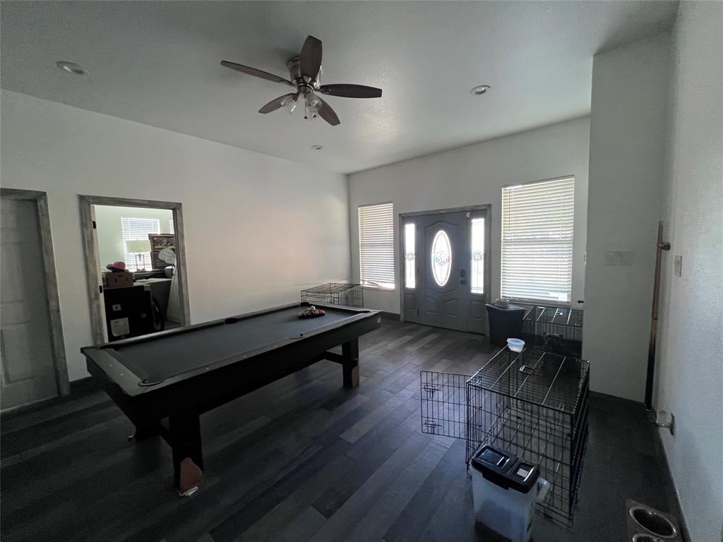High-ceilinged interior featuring wood-finish flooring, recessed lighting, a ceiling fan, and an entry door with an oval decorative glass insert