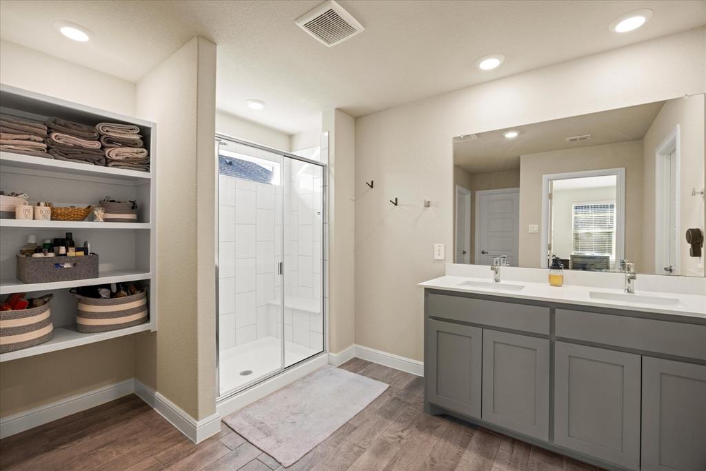 Walk-in shower and double vanity with ample shevling