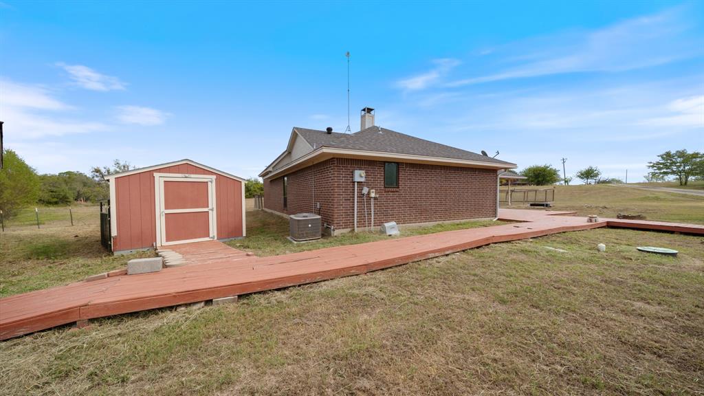 Brick exterior, detached storage shed, and wraparound wood decking