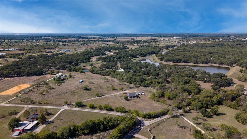 Expansive acreage featuring mature tree clusters, open pasture land, and a natural pond