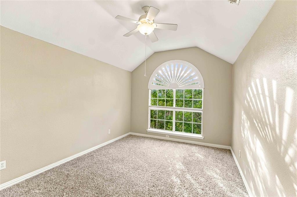 Vaulted ceiling, arched window with decorative fanlight, and ceiling fan with integrated lighting