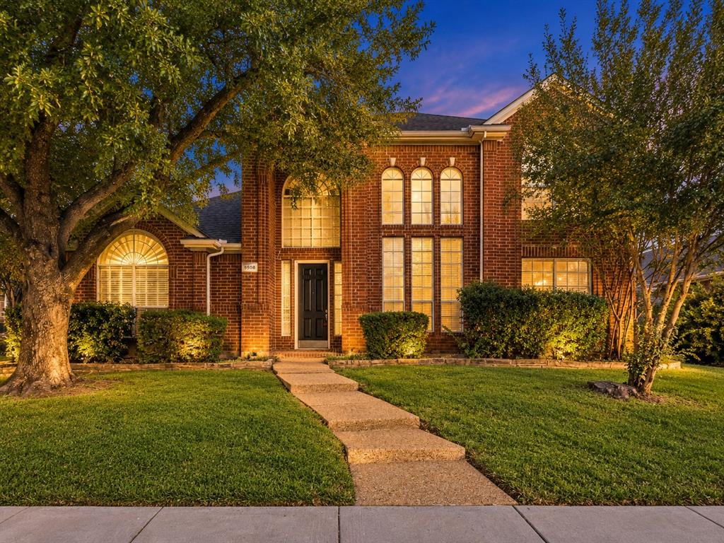 Traditional red brick exterior featuring a multi-gabled roofline, arched window detailing, and a concrete paver walkway leading to the front entry Traditional red brick exterior featuring a multi-gabled roofline, arched window detailing, and a concrete paver walkway leading to the front entry
