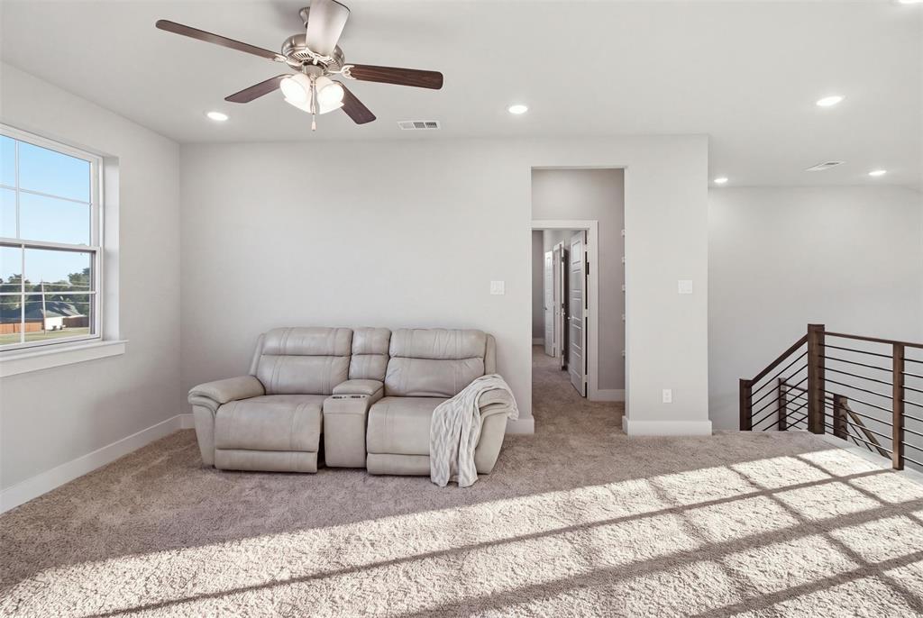 Neutral carpeting, recessed lighting, ceiling fan with integrated light fixture, and metal horizontal rail staircase