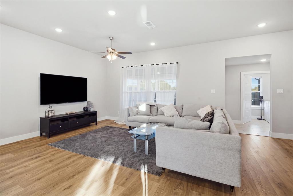 Living area featuring wood-finish flooring, recessed lighting, and a ceiling fan