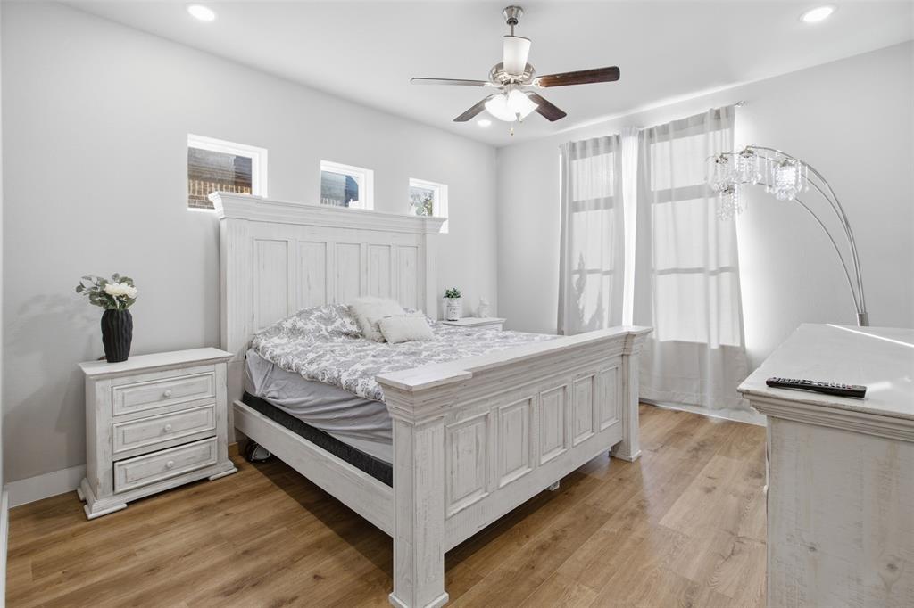 Wood-finish flooring, recessed lighting, ceiling fan with light kit, and multiple windows providing natural light