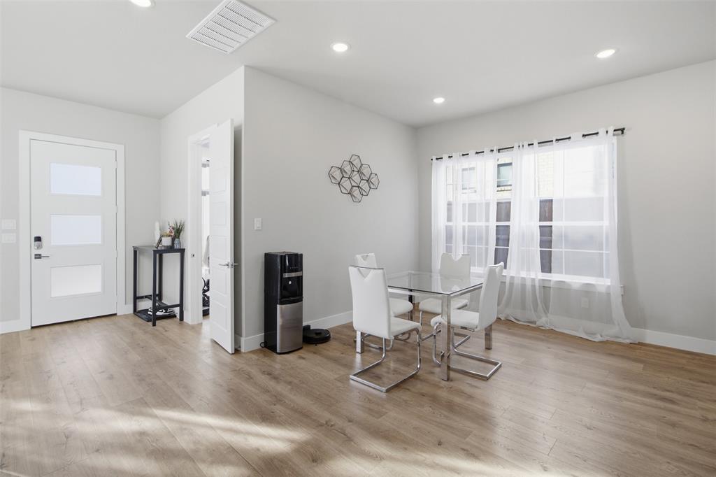 Wood-finish flooring, recessed lighting, and a white entry door featuring three frosted glass panels