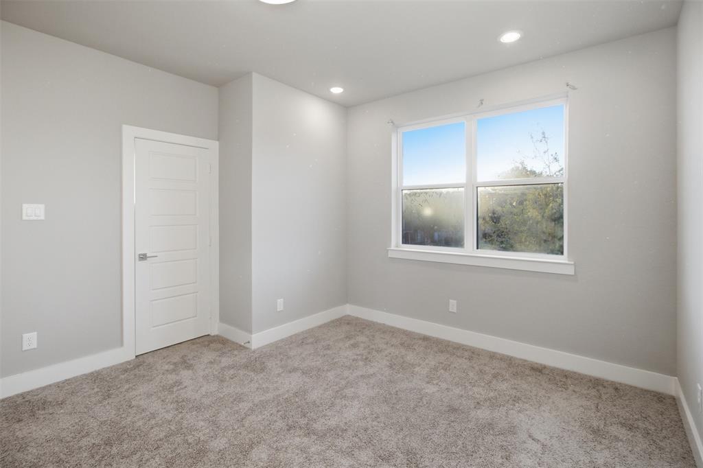 Neutral-toned interior featuring wall-to-wall carpeting, recessed ceiling lighting, and a multi-panel interior door